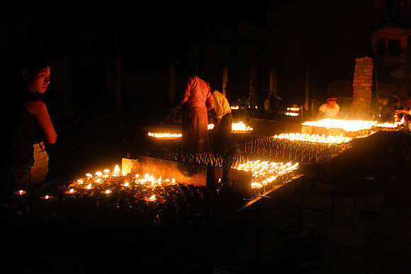 People in between candles, Boudhanath Stupa, Kathmandu, Nepal 1-1