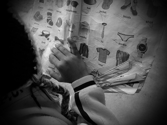 Orphan looking at school book