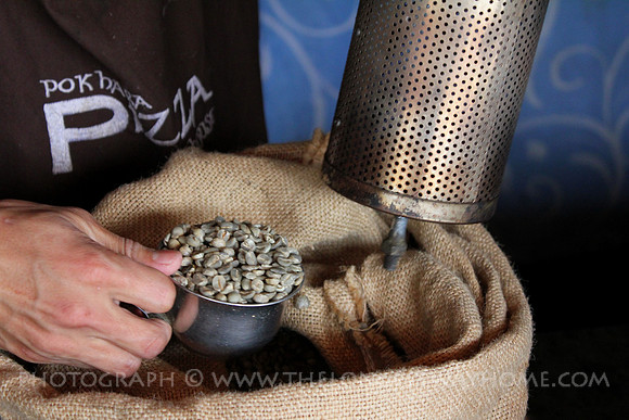 Green coffee beans being loaded into a roaster