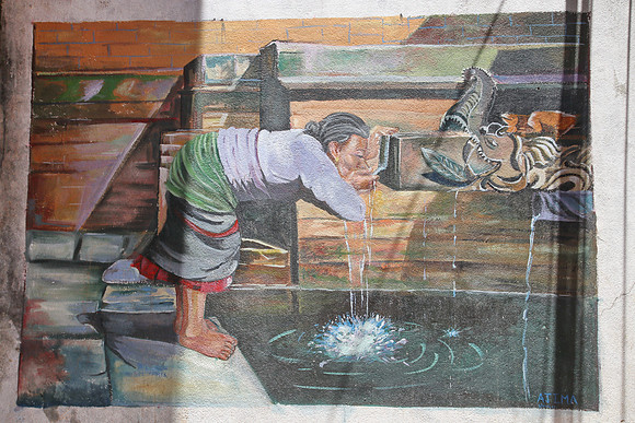 Street art of a woman drinking from a Hiti