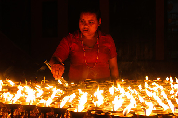 Woman lighting candles at night -Boudhanath Stupa, Kathmandu, Nepal 13-12
