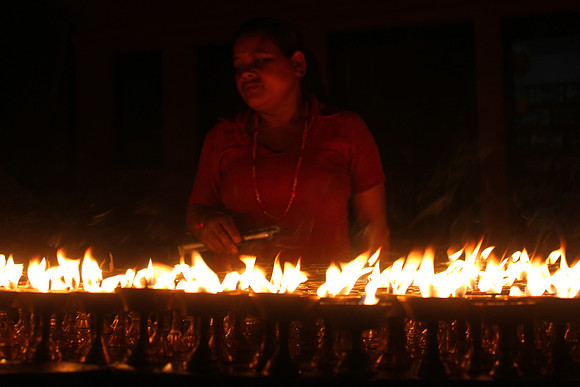 Woman lighting candles at night -Boudhanath Stupa, Kathmandu, Nepal 11-10