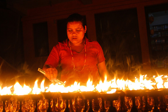 Woman lighting candles at night -Boudhanath Stupa, Kathmandu, Nepal 12-11
