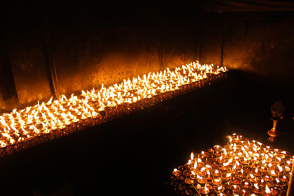 Two tables of candles at Boudhanath Stupa, Kathmandu, Nepal 15-14