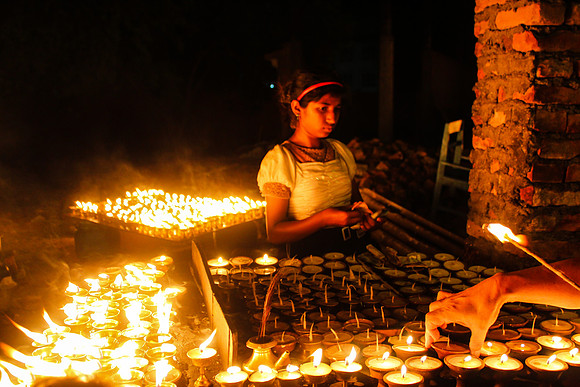 Small girl between candles at Boudhanath Stupa, Kathmandu, Nepal 9-9